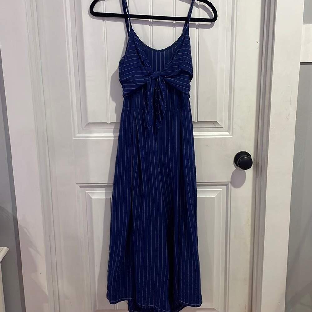 Navy blue romper with an open back. The romper has spaghetti straps and is flowy